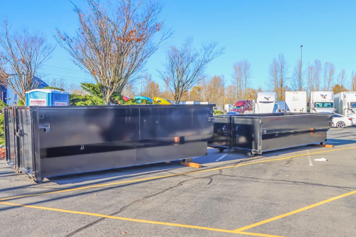 Professional dumpster rental service with roll-off container on residential driveway in Ira